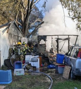A four-person fire crew, along with their ladder truck and a safety officer, from Joint Base San Antonio-Fort Sam Houston, assist with ensuring a house fire is completely extinguished in Converse, Texas, Nov. 25, 2019.