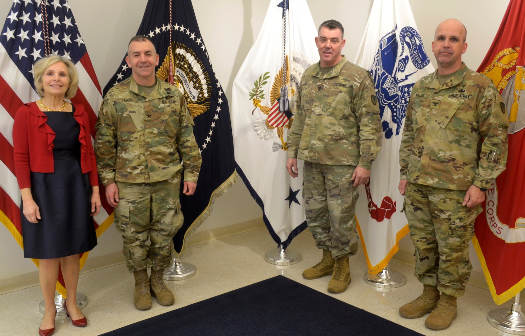 Army Col. Michael Lalor, Army Medical Logistics Command commander, left center, Sgt. Maj. Corey Lord, AMLC sergeant major, right center, and Col. Timothy Walsh, AMLC deputy commander, right, pose for a photo with Linda Farrell, DLA Troop Support Flag Room supervisor, at DLA Troop Support Jan. 7, 2020 in Philadelphia.