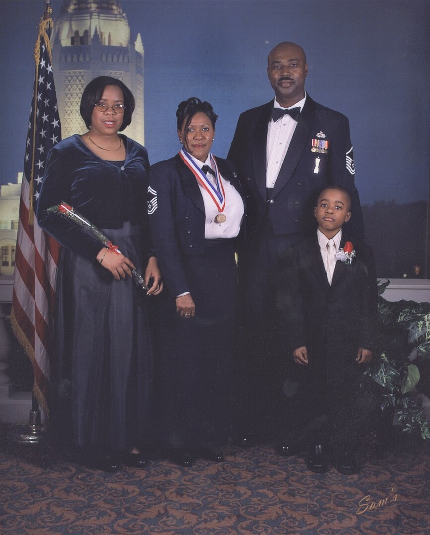 Family of four, dressed in black tie attire, pose for a photo during the Randolph Air Force Base 2002 Chief Induction ceremony.