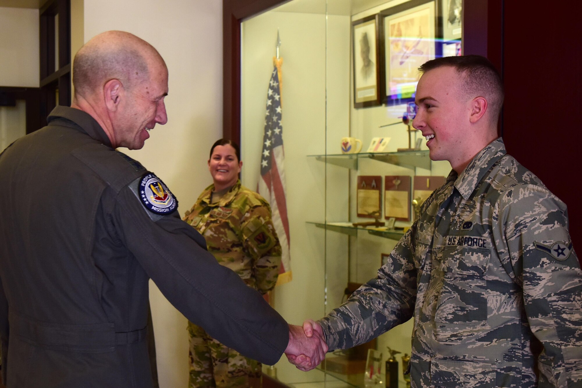 General Mike Holmes, Commander of Air Combat Command, shakes hands with an Airmen who has excelled within his squadron.