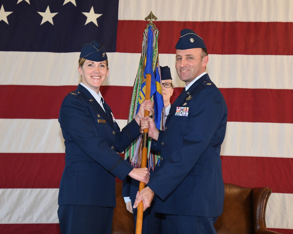 Col. Samantha Weeks, 14th Flying Training Wing commander, passes the 14th Operations Group guidon to Lt. Col. William McElhinney as he assumes command of the 14th OG Jan. 6, 2020, on Columbus Air Force Base, Miss. McElhinney is the former commander of the 43rd Flying Training Squadron, which administers and executes the Air Education and Training Command/Air Force Reserve Command Associate Instructor Pilot Program and provides Active, Guard, Reserve and Traditional Reserve IPs to augment the cadre of active-duty pilots conducting pilot training. (U.S. Air Force photo by Elizabeth Owens)