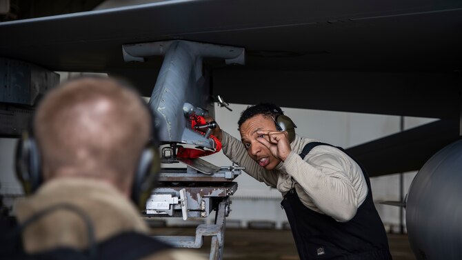 Airman 1st Class Andre Patterson, a 14th Aircraft Maintenance Unit weapons load crew member, directs his ‘three man’ during the placement of the jammer at Misawa Air Base, Japan, Jan. 7, 2020. The three-man team is responsible for making sure the munitions are safe and match mission requirements. (U.S. Air Force photo by Airman 1st Class China M. Shock)
