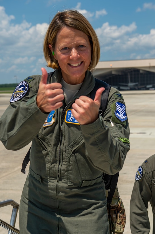 Picture shows Col. Holbeck holding two thumbs up before boarding and E-8C JSTARS aircraft.