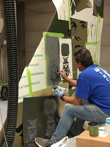 Klamath Falls, Ore., artist Chris Young paints an image of the Medal of Honor in three-dimensional relief on the new flagship of the 173rd Fighter Wing fleet, Dec. 23, 2019.