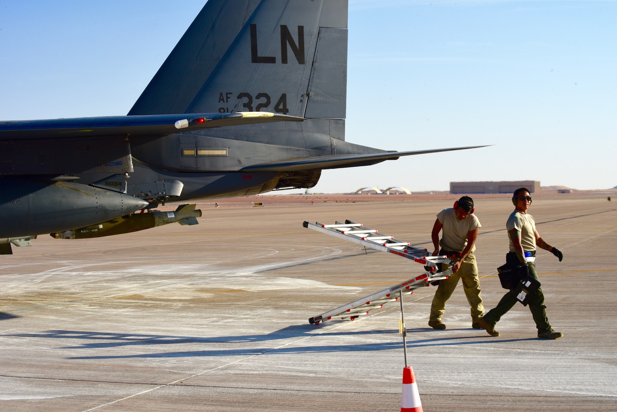 Two U.S. Air Force crew chiefs assigned to the 378th Expeditionary Maintenance Squadron walk on the flight line after marshalling an F-15E Strike Eagle at Prince Sultan Air Base, Kingdom of Saudi Arabia, Jan. 4, 2020.