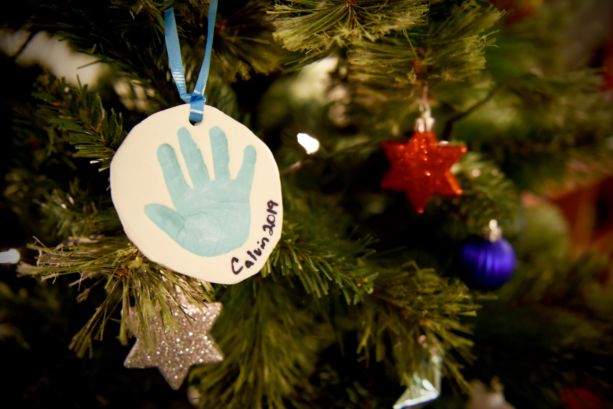 A Christmas ornament of Staff Sgt. Joseph Carter’s newborn son’s handprint hangs from a Christmas tree, Jan. 9, 2020, at Incirlik Air Base, Turkey. The ornament stands as a reminder that his son is with him for the holidays, despite the distance. (U.S. Air Force photo by Staff Sgt. Eric Mann)