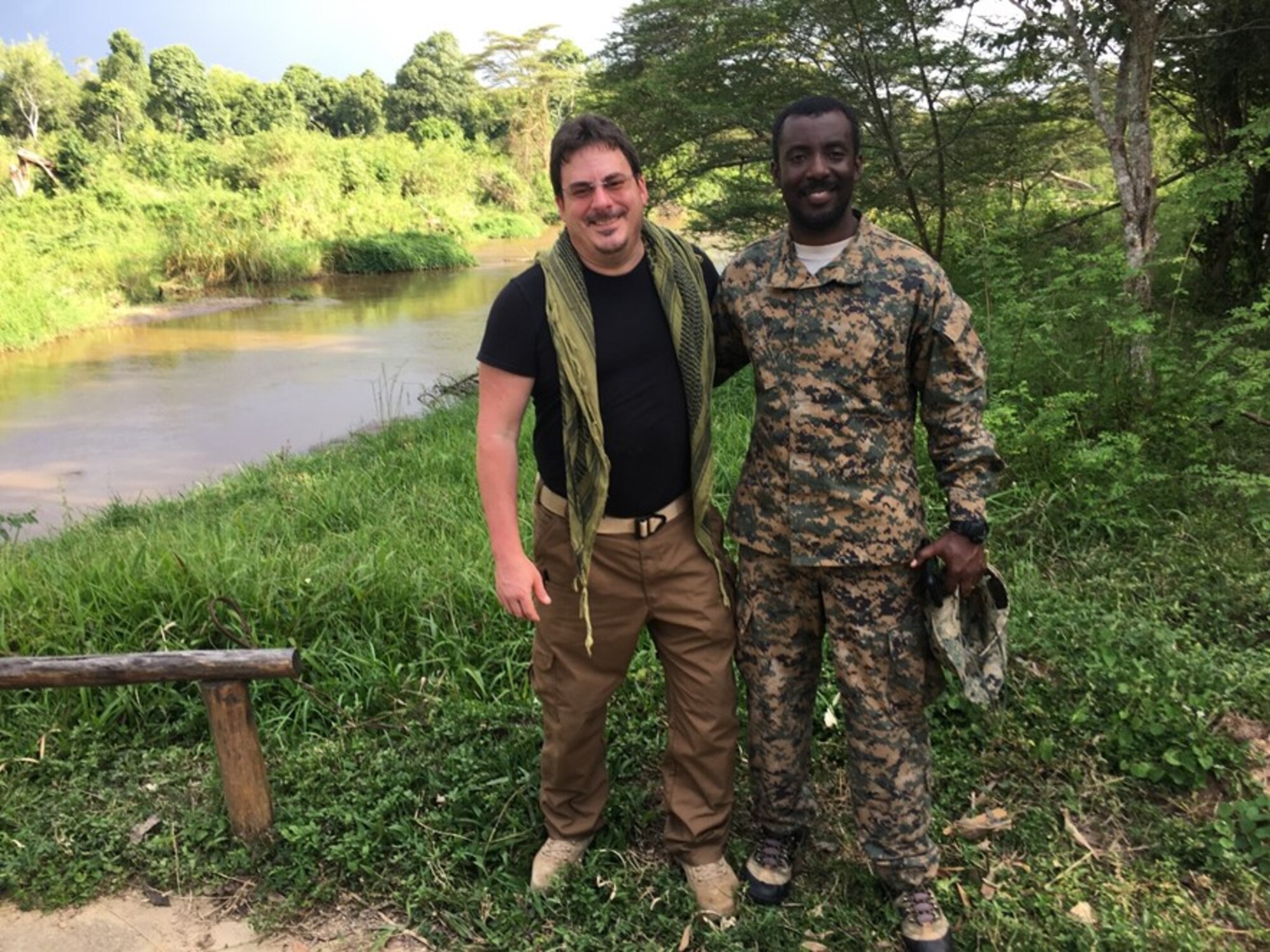 Air Force Office of Special Investigations Force Protection Detachment Uganda Special Agent In Charge Keith Ide is joined by the Uganda Special Force Command Commando/Battalion Commander near the command post along the Ntungwe River in Queen Elizabeth National Park, Uganda, after the successful hostage rescue. SA Ide directed strategic intelligence, surveillance and reconnaissance to support the Ugandan Commandos and rescue operations in the Democratic Republic of the Congo. (Courtesy photo)