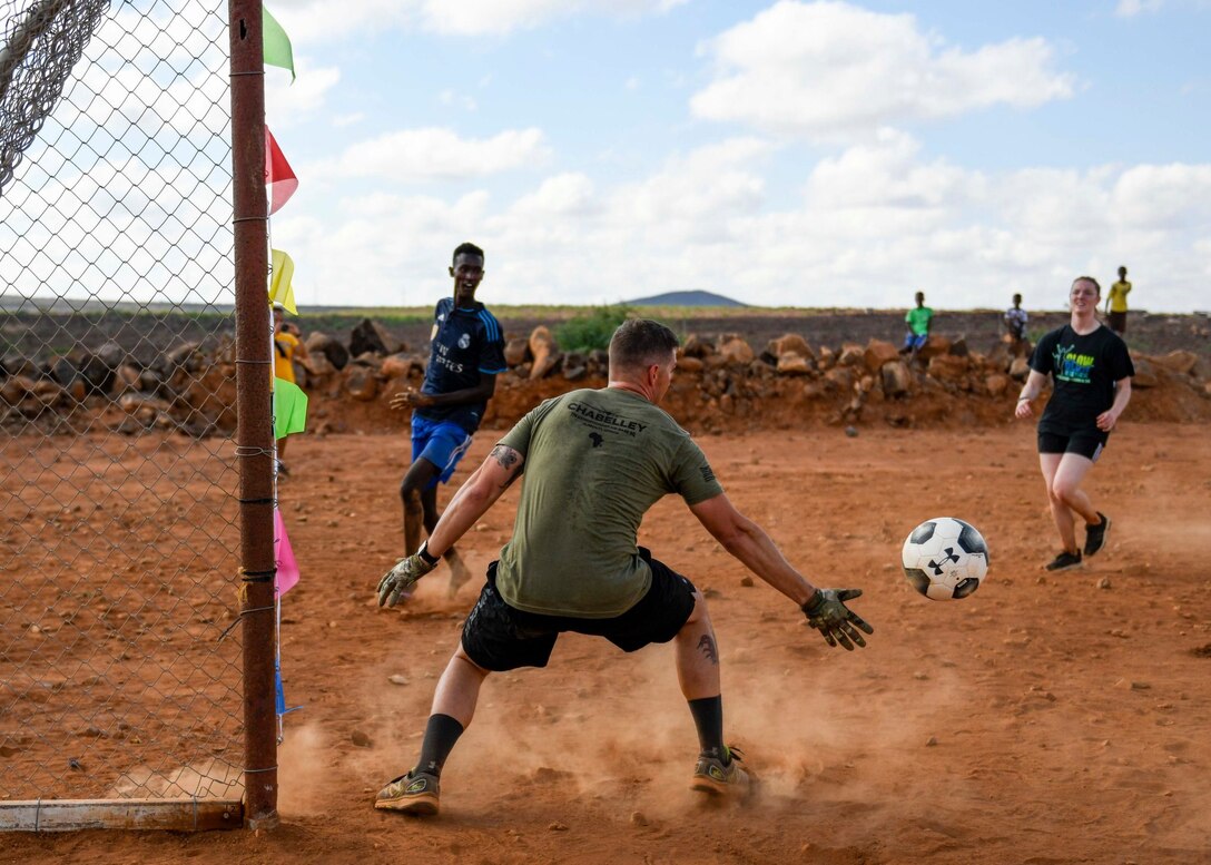 U.S. service members play a game of soccer with Chabelley villagers during the grand opening of the Chabelley Village soccer field in Chabelley, Djibobuti, Dec. 30, 2019. U.S. service member volunteers constructed the soccer field. (U.S. Air Force photo by Staff Sgt. J.D. Strong II)