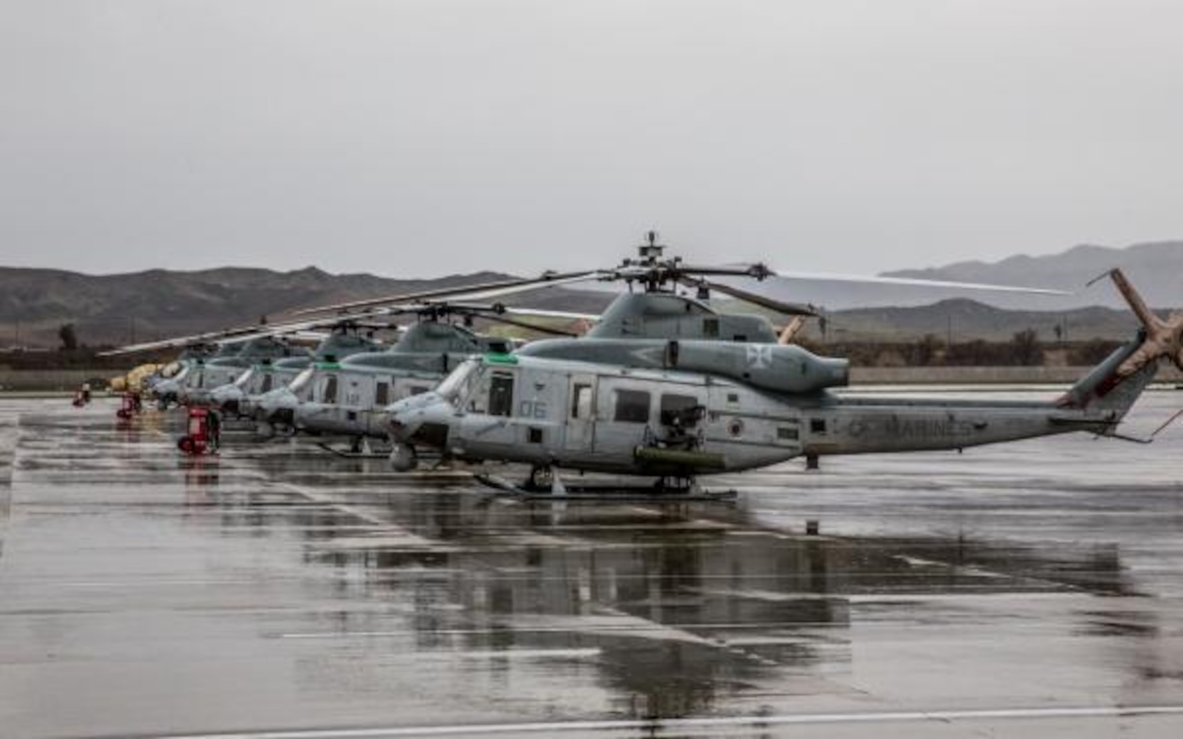 UH-1Y Venom helicopters sit in the rain