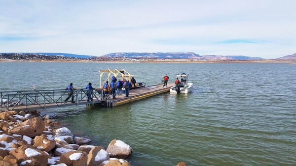 Volunteers (in blue) prepare to board a boat to help count eagles from the lake during the annual eagle watch at Abiquiu Lake, Jan. 4, 2020. This year, 66 volunteers participated in counting eagles from three stationary positions on shore and two boats on the lake.