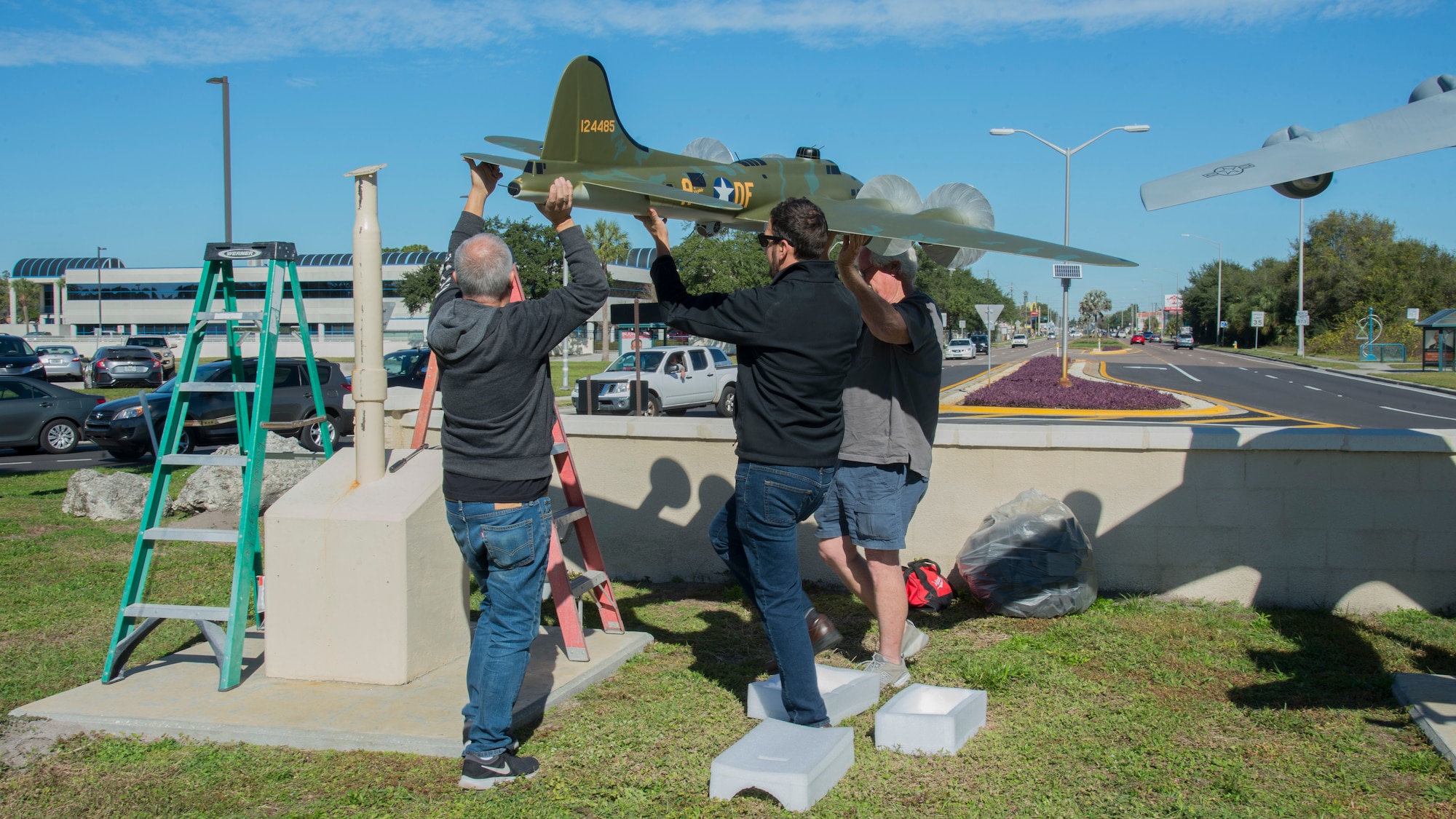 Gino Galvez (left), an Atlantic-Models scale model manufacturer, Stephen Ove (center), the 6th Air Refueling Wing historian and Roger Jarman (right), the Atlantic-Models vice president, lift a scale model of the Memphis Belle, a B-17 Flying Fortress onto a display-stand Jan. 8, 2020, at MacDill Air Force Base, Fla.  The Memphis Belle was stationed at MacDill AFB in 1942, went on to complete 25 combat missions against Nazi Germany. (U.S. Air Force photo by Airman 1st Class Shannon Bowman)