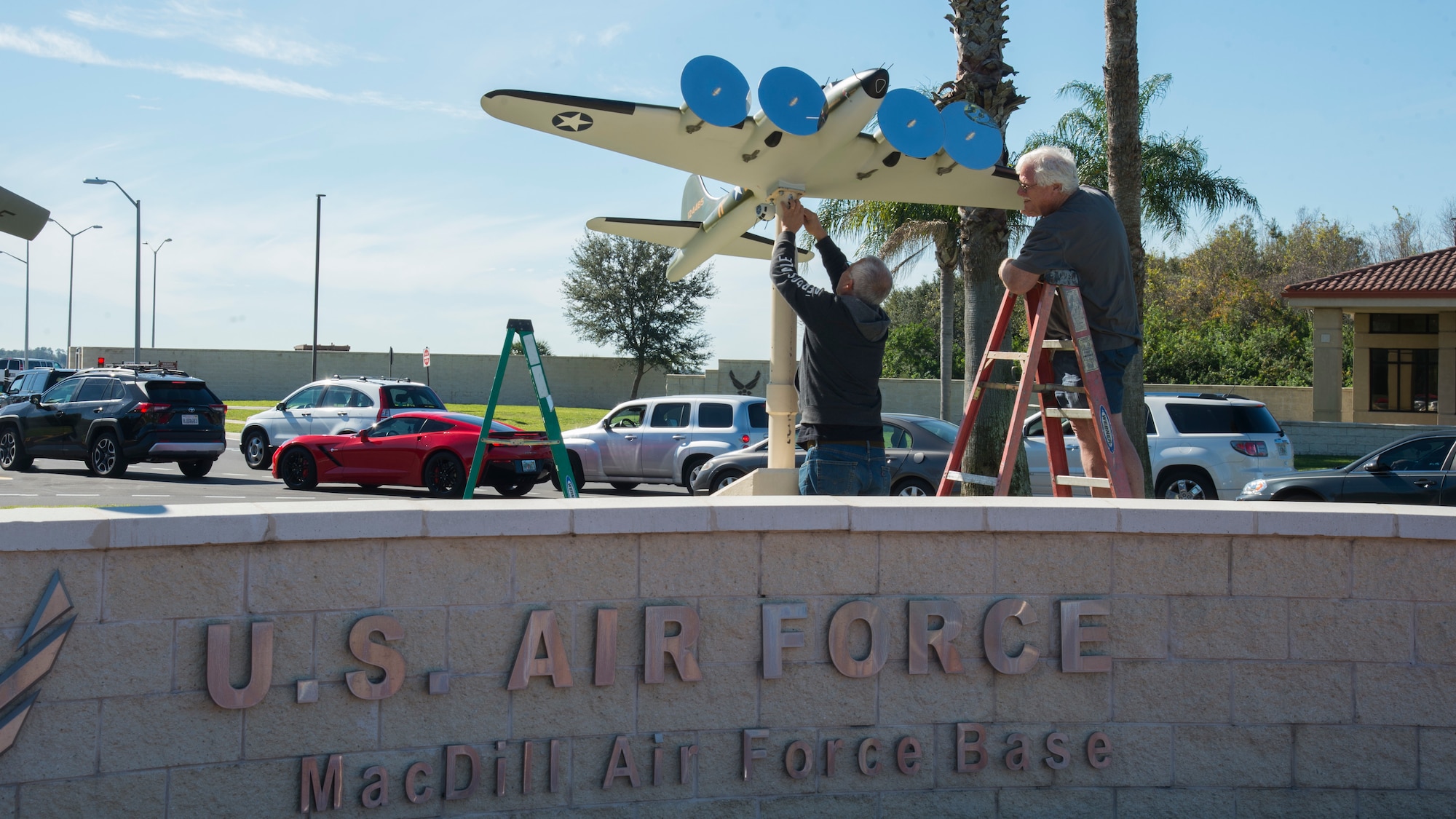 Gino Galvez (center), an Atlantic-Models scale model manufacturer, and Roger Jarman (right), the Atlantic-Models vice president, install a scale model of the Memphis Belle, a B-17 Flying Fortress onto a display-stand Jan. 8, 2020, at MacDill Air Force Base, Fla.  The Memphis Belle, which was stationed at MacDill AFB in 1942, was the first B-17 Bomber to return to the U.S. after completing 25 successful combat missions during WWII without losing a single member of the aircrew. (U.S. Air Force photo by Airman 1st Class Shannon C. Bowman)