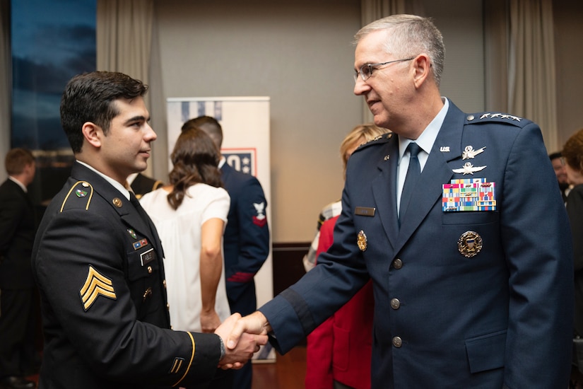 Two men shake hands.