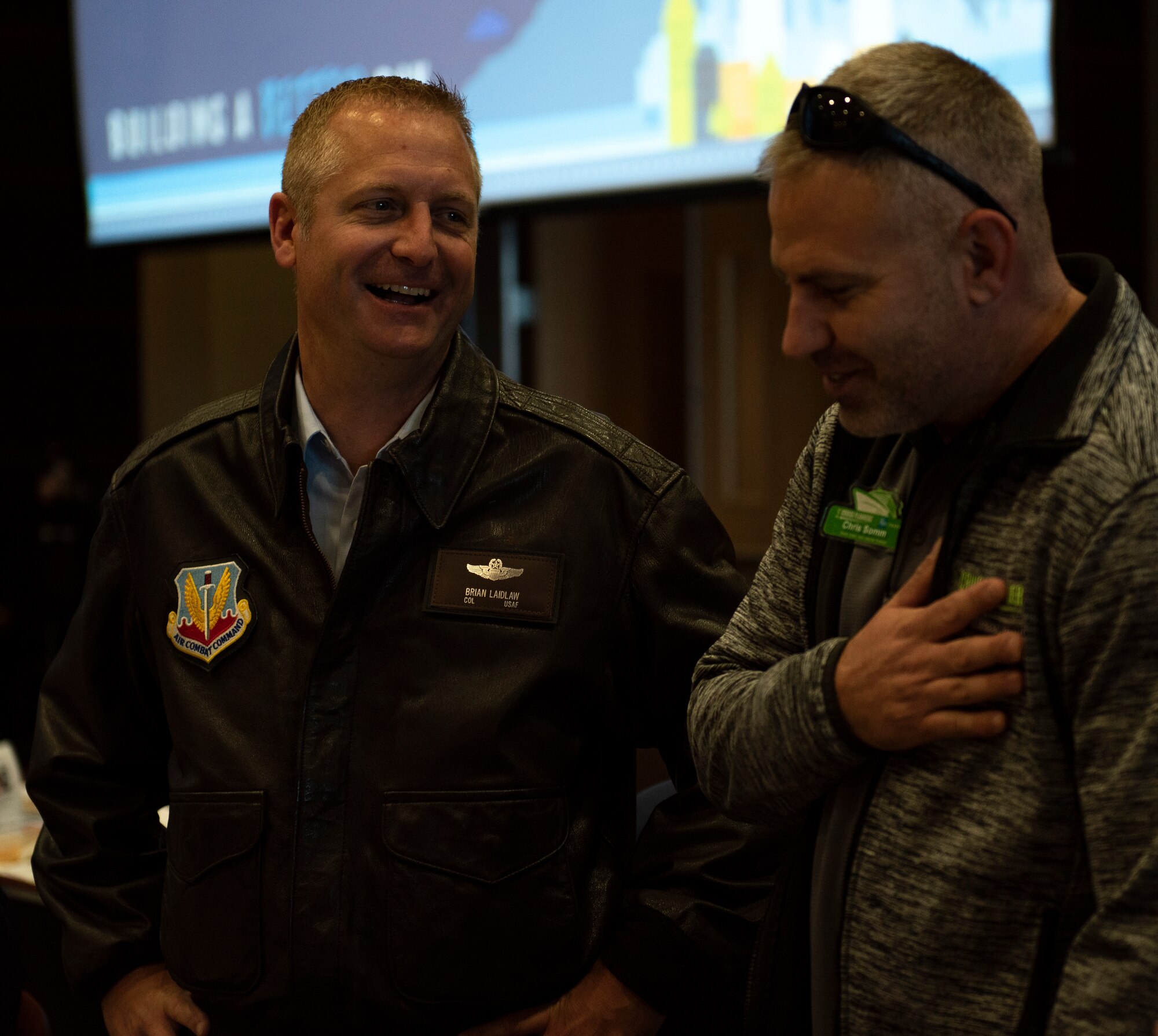 U.S. Air Force Col. Brian Laidlaw, 325th Fighter Wing commander, laughs with a local community member at the Bay County Chamber of Commerce monthly meeting at Panama City, Florida, Jan. 10, 2020. Laidlaw, along with U.S. Air Force Col. Travis Leighton, Tyndall Program Management Office director, and U.S. Navy Cmdr. Kevin Christenson, Naval Support Activity Panama City commanding officer, attended the First Friday meeting as representatives of military communities in the local area. (U.S. photo by Staff Sgt. Magen M. Reeves)