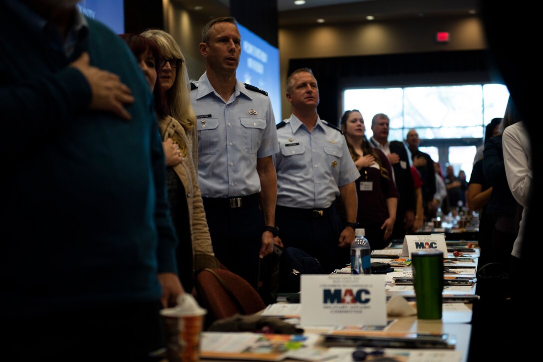 U.S. Air Force Col. Travis Leighton, Tyndall Program Management Office director, left, and U.S. Air Force Col. Brian Laidlaw, 325th Fighter Wing commander, right, recite the Pledge of Allegiance at the Bay County Chamber of Commerce monthly meeting at Panama City, Florida, Jan. 10, 2020. Laidlaw, Leighton, and U.S. Navy Cmdr. Kevin Christenson, Naval Support Activity Panama City commanding officer, attended the First Friday meeting as representatives of military communities in the local area. (U.S. photo by Staff Sgt. Magen M. Reeves)