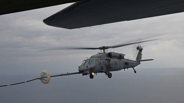 An HH-60G Pave Hawk assigned to the 33rd Rescue Squadron performs helicopter air-to-air refueling with an MC-130J Commando II from the 17th Special Operations Squadron above the Pacific Ocean during Exercise Westpac Rumrunner Jan. 10, 2020. Westpac Rumrunner represents an evolution of 18th Wing assets and capability to work with joint partners in defense of American allies and to ensure a free and open Indo‐Pacific. (U.S. Air Force photo by Staff Sgt. Benjamin Sutton)