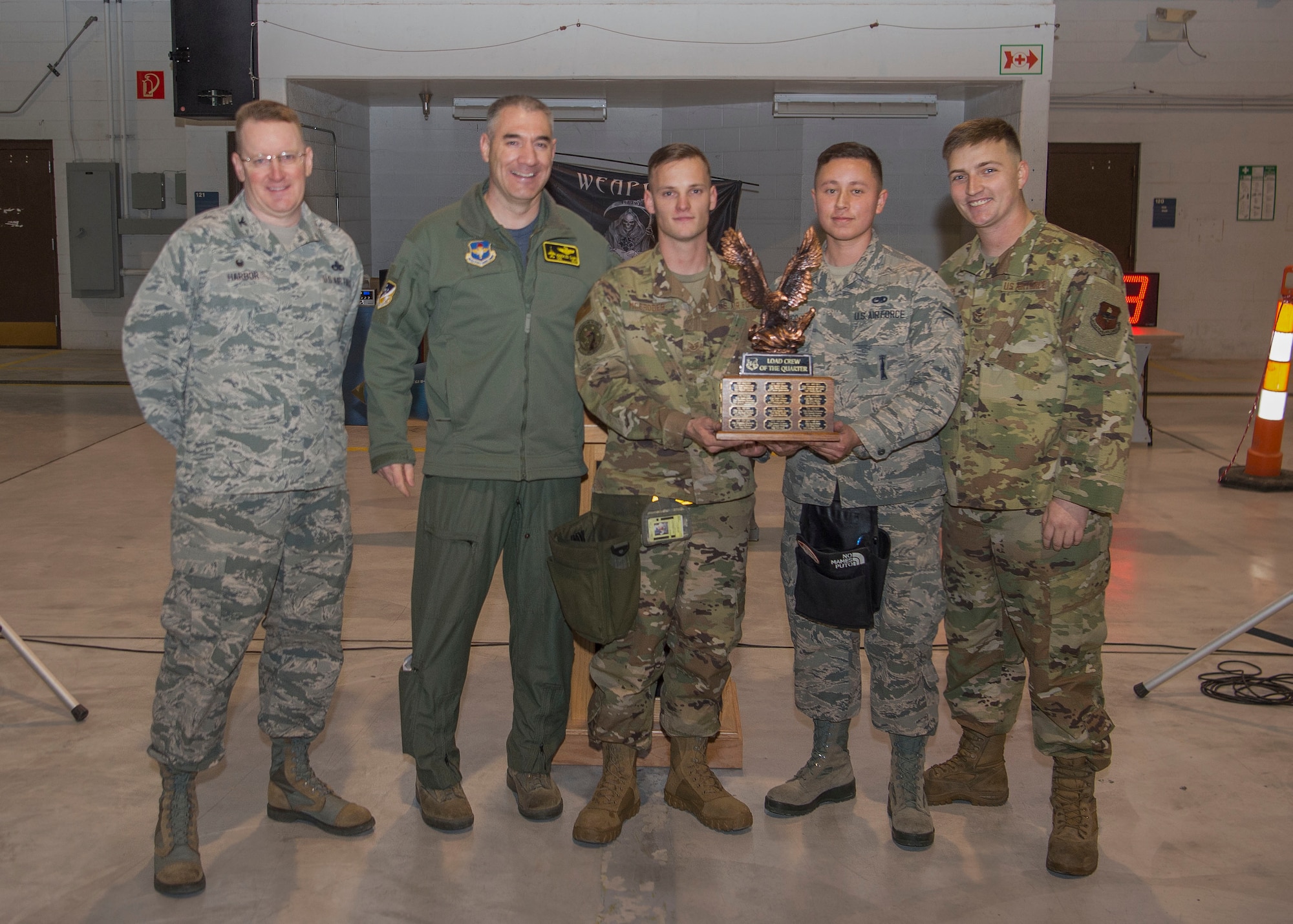 Col. Joseph Campo, 49th Wing commander (second from left), and Col. Tim Harbor, 49th Maintenance Group commander, present the first place trophy to weapons load crew members from the 314th Fighter Squadron during the fourth quarter load competition awards ceremony, Jan. 10, 2020, on Holloman Air Force Base, N.M. 12 Airmen from the 9th Aircraft Maintenance Unit, 29th AMU, 314th FS and 311th FS competed to see who could load munitions onto their respective aircraft the fastest. (U.S. Air Force photo by Airman 1st Class Quion Lowe)