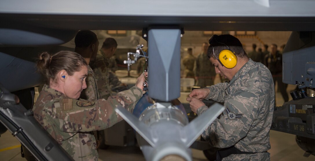 Load crew members from the 9th Aircraft Maintenance Unit prepare to load an inert bomb onto an MQ-9 Reaper, Jan. 10, 2020, on Holloman Air Force Base, N.M. 12 Airmen from the 9th AMU, 29th AMU, 314th Fighter Squadron and 311th FS competed to see who could load munitions onto their respective aircraft the fastest. (U.S. Air Force photo by Airman 1st Class Quion Lowe)