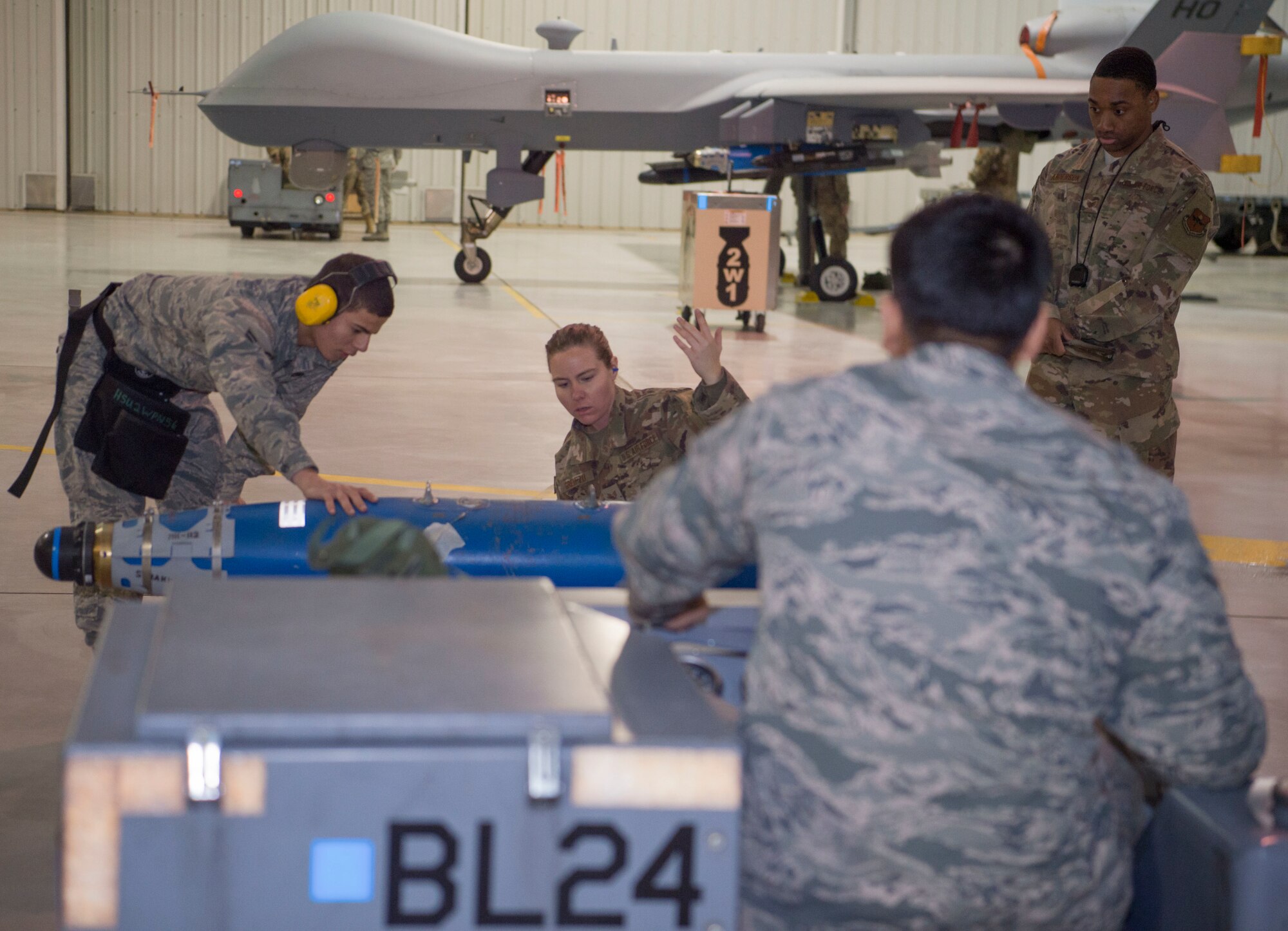 Load crew members from the 9th Aircraft Maintenance Unit prepare to load an inert bomb onto an MQ-9 Reaper, Jan. 10, 2020, on Holloman Air Force Base, N.M. 12 Airmen from the 9th AMU, 29th AMU, 314th Fighter Squadron and 311th FS competed to see who could load munitions onto their respective aircraft the fastest. (U.S. Air Force photo by Airman 1st Class Quion Lowe)
