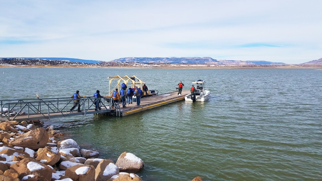 Volunteers (in blue) prepare to board a boat to help count eagles from the lake during the annual eagle watch at Abiquiu Lake, Jan. 4, 2020. This year, 66 volunteers participated in counting eagles from three stationary positions on shore and two boats on the lake.
