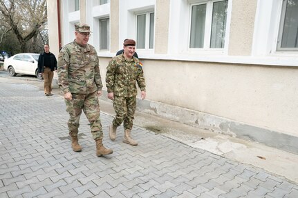 Two men walk outside a building.