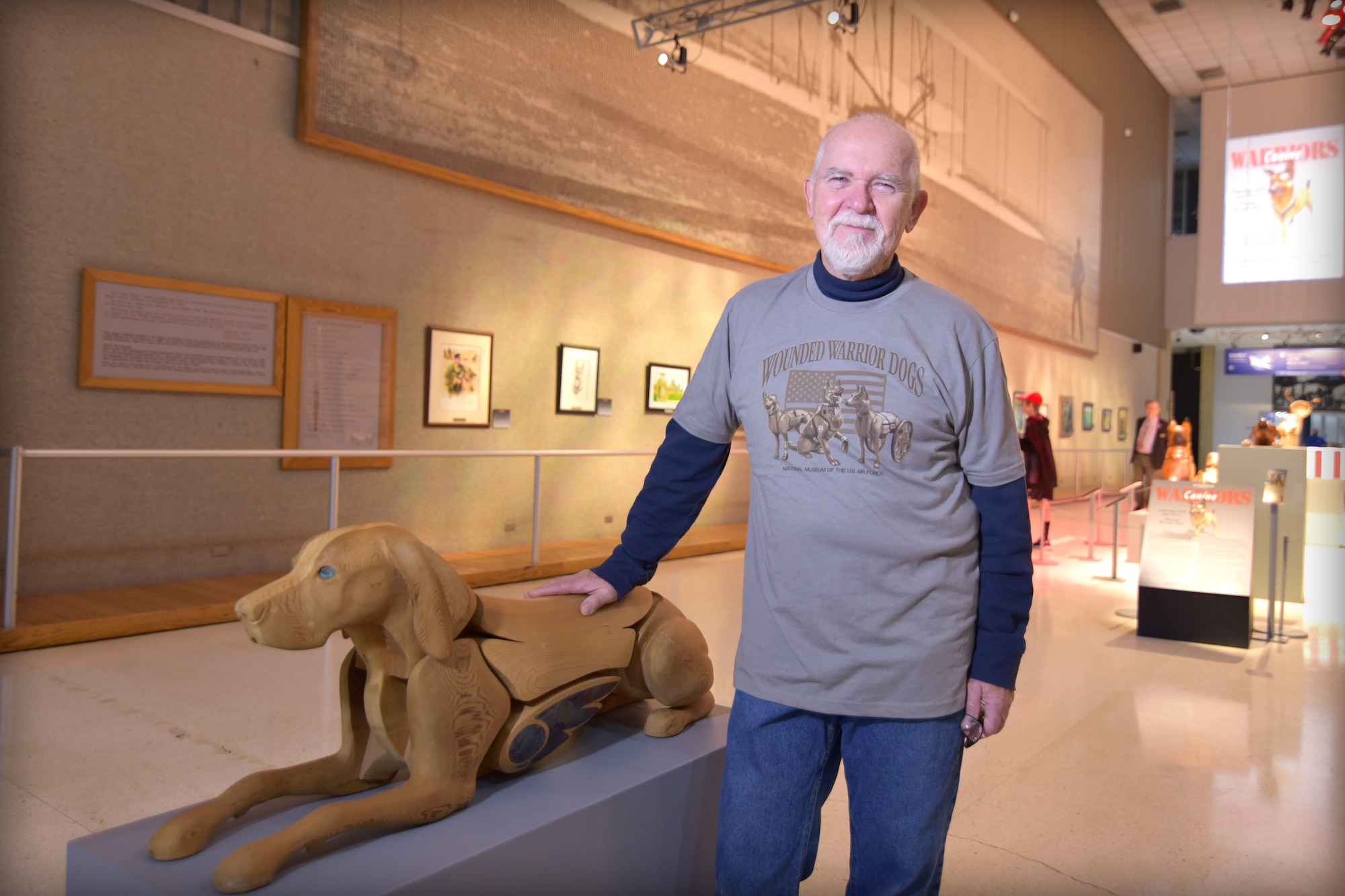 Artist James Mellick stands next to one of his dog sculptures.