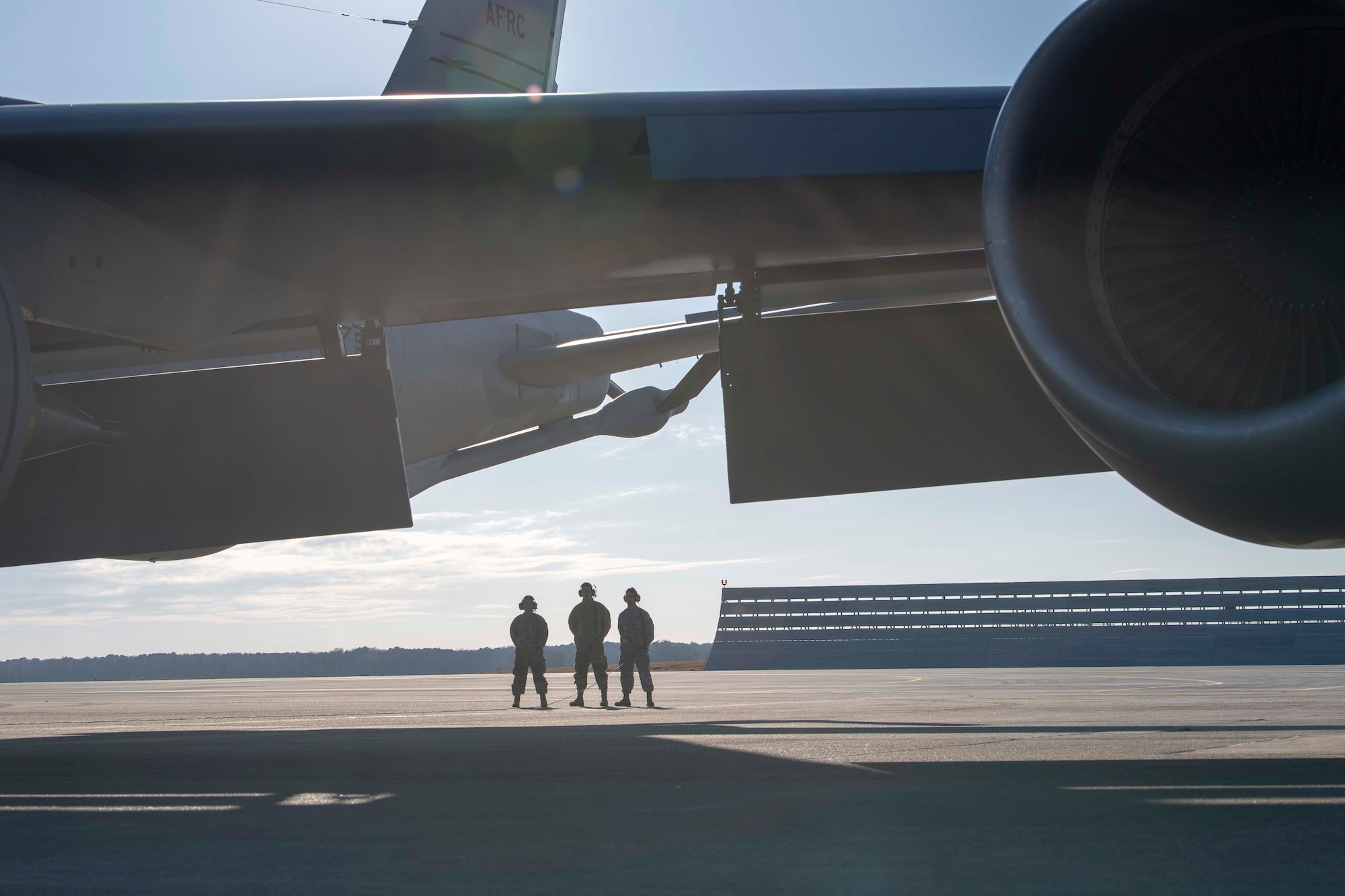 U.S. Air Force Staff Sgt. Irang K. McClellan, Staff Sgt. Jose A. Reyes and Airman 1st Class Edwin Rodriguez, all 911th Air Refueling Squadron (ARS) dedicated crew chiefs, stand in the distance as they conduct pre-flight checks before takeoff from Seymour Johnson Air Force Base, North Carolina, Dec. 12, 2019. The 911 ARS prepared for their final mission in KC-135 Stratotanker. (U.S. Air Force photo by Staff Sgt. Mary McKnight)