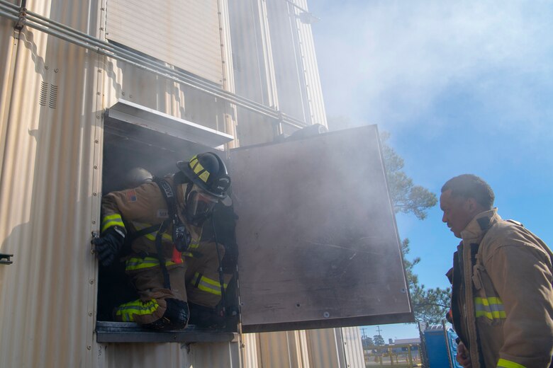 U.S. Air Force Senior Airman Kyler Rogers-McCoy, a 916th Civil Engineer Flight (CEF) firefighter, exits a window in preparation of a simulated victim extraction on Seymour Johnson Air Force Base, North Carolina, Jan. 9, 2020. Tech. Sgt. Christopher Perry, the 916 CEF assistant chief of operations, observed to ensure proper techniques were used at all times for safety concerns. (U.S. Air Force photo by Staff Sgt. Mary McKnight)