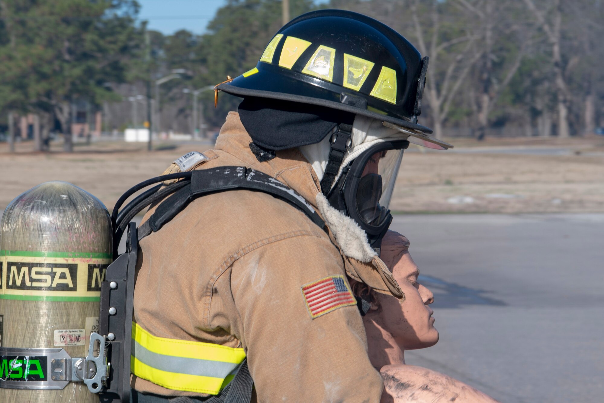 U.S. Air Force Senior Airman Kyler Rogers-McCoy, a 916th Civil Engineer Flight firefighter, executes a firefighter technique to remove a simulated victim from the Immediate Dangerous to Life or Health (IDLH) environment on Seymour Johnson Air Force Base, North Carolina, Jan. 9, 2020. Victims are removed from the IDLH to prevent inhalation of harmful carcinogens. (U.S. Air Force photo by Staff Sgt. Mary McKnight)