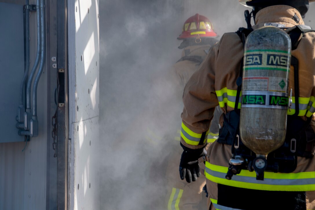 U.S. Air Force Tech. Sgt. Christopher Perry, the 916 Civil Engineer Flight (CEF) assistant chief of operations and Lt. Col. Joseph Winchester, 916th Mission Support Group (MSG) commander make entry to a simulated smoke-filled structure on Seymour Johnson Air Force Base, North Carolina, Jan. 9, 2020. The 916 CEF is a unit within the 916 MSG. (U.S. Air Force photo by Staff Sgt. Mary McKnight)