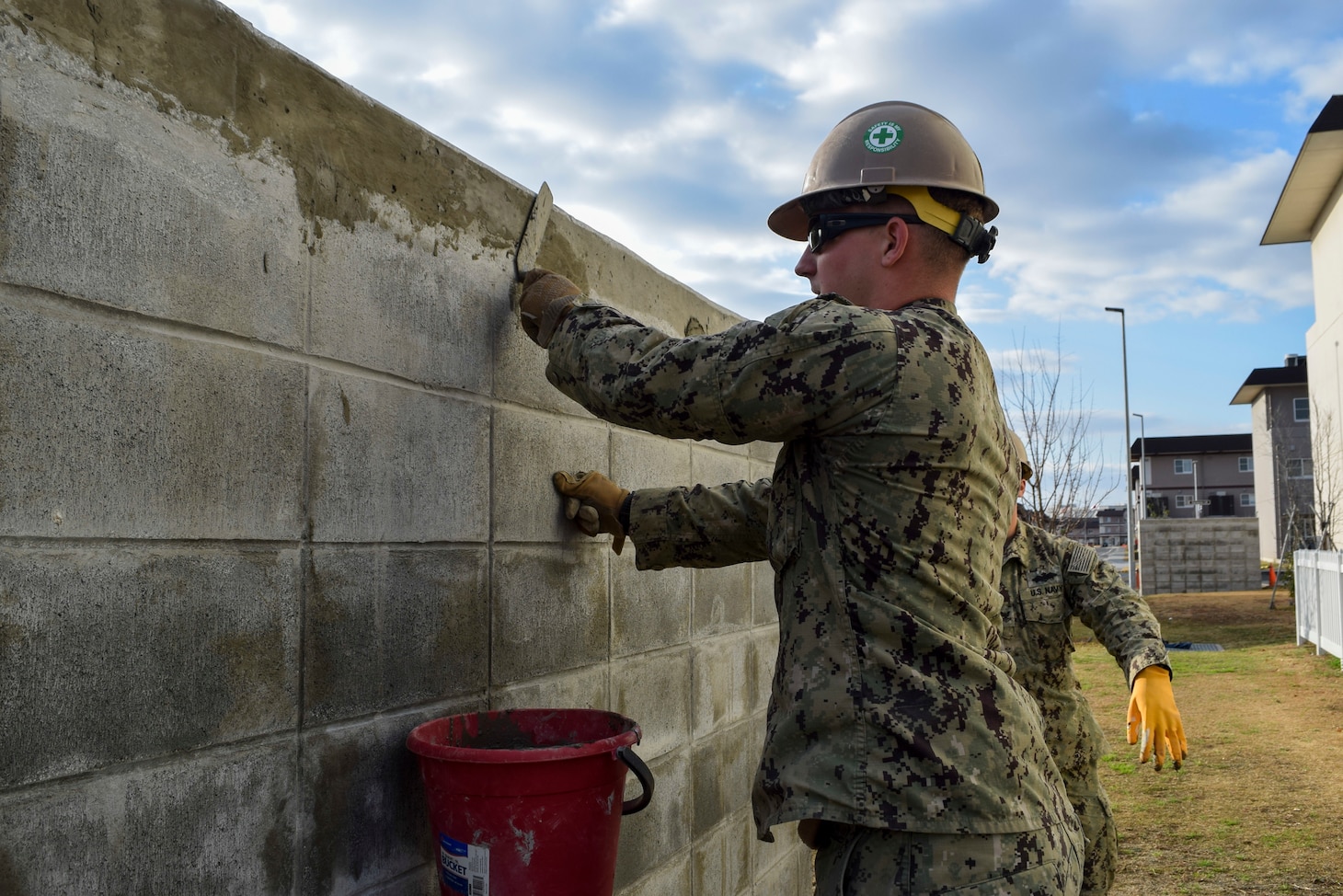 IWAKUNI, Japan (Jan. 8, 2020) Steelworker 3rd Class William Shutt, from Montpelier, Virginia, deployed with Naval Mobile Construction Battalion (NMCB) 5’s Detail Iwakuni, cleans cement blocks at the environmental enclosure project prior to painting. NMCB-5 is deployed across the Indo-Pacific region conducting high-quality construction to support U.S. and partner nations to strengthen partnerships, deter aggression, and enable expeditionary logistics and naval power projection.