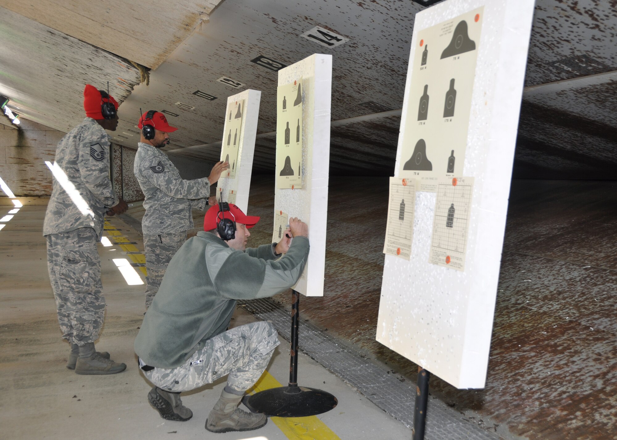 From left, Master Sgt. Henry Relf, Tech. Sgt. Shannon Jones and Staff Sgt. Jonathan Pilgrim, 908th Security Forces Squadron Combat Arms instructors, review targets Nov. 2, 2019, in the firing bay at Maxwell AFB, Alabama. Every year, the SFS defenders have to score high enough to re-qualify with both the M4 carbine and the M9. (U.S. Air Force photo by Airman 1st Class Shelby S. Thurman)