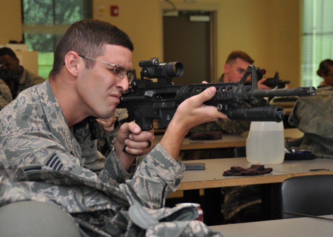 Staff Sgt. Jacob Williams, 908th Security Forces Squadron defender, aims his M4 carbine Nov. 2, 2019, in a classroom at Maxwell AFB, Alabama. Airmen are required to have hours of classroom instruction by Combat Arms instructors before they can use their weapons at the firing range. (U.S. Air Force photo by Airman 1st Class Shelby S. Thurman)