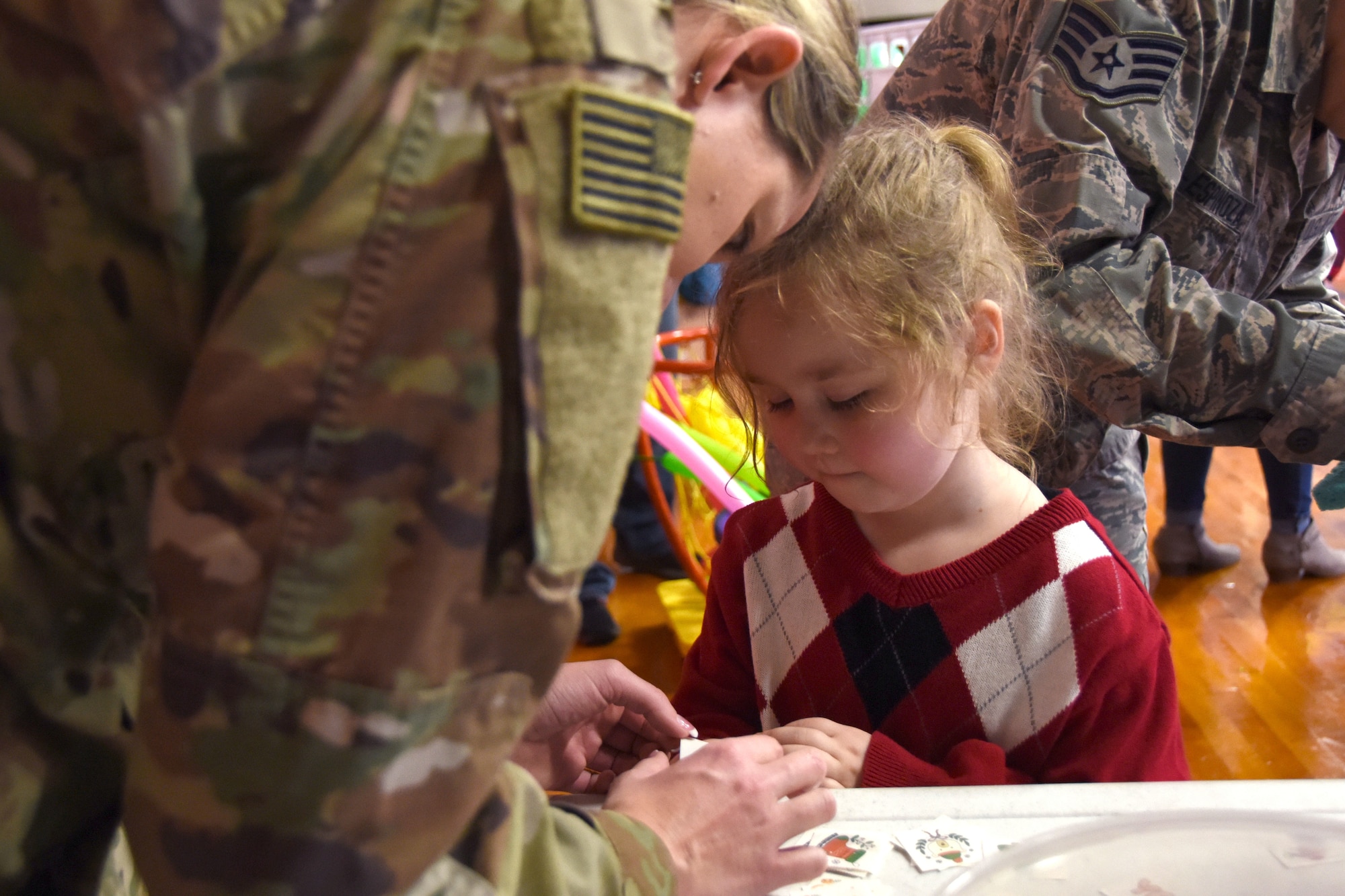 A young student of Badin Elementary School (B.E.S.) selects a temporary hand tattoo during Operation Santa held at B.E.S., Badin, N.C., Dec. 14th, 2019.  Operation Santa is an annual event run by the Chapter 7 organization of the North Carolina Air National Guard (NCANG) which chooses select schools to provide assistance to families during the holiday season. This year, the NCANG provided presents, lunch, music, bouncy castles and a Santa. The NCANG also partnered with the local Target for food donations.