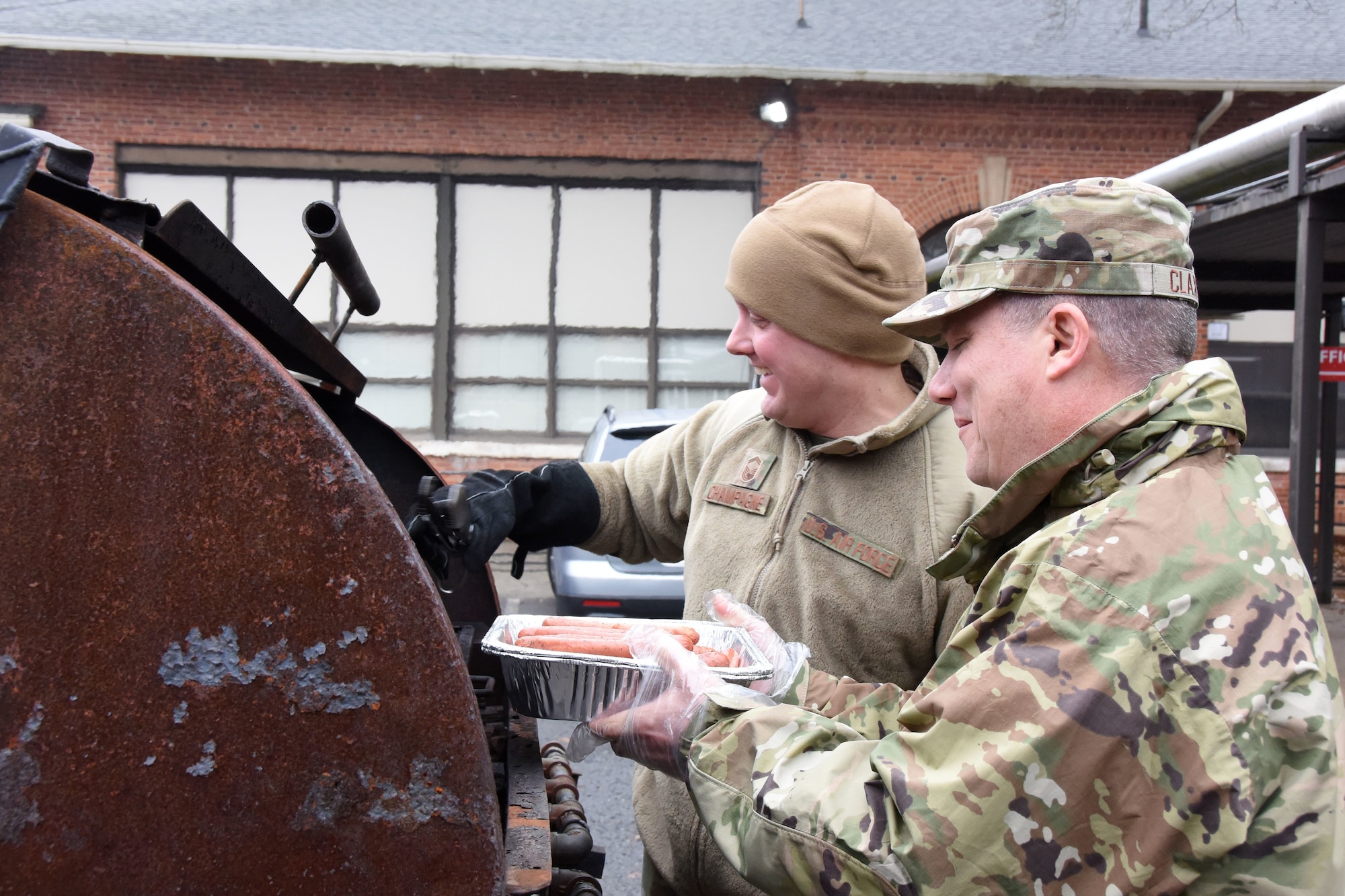 U.S. Air Force Senior Master Sgt. Carl Champagne (left), 263rd Flight Operations superintendent and Lt. Col. Bradley Claxton (right), 263rd Combat Communications commander, enjoy grilling nearly 400 hot dogs during Operation Santa held at Badin Elementary School, Badin, N.C., Dec. 14th, 2019.  Operation Santa is an annual event run by the Chapter 7 organization of the North Carolina Air National Guard (NCANG) which chooses select schools to provide assistance to families during the holiday season. This year, the NCANG provided presents, lunch, music, bouncy castles and a Santa. The NCANG also partnered with the local Target for food donations.