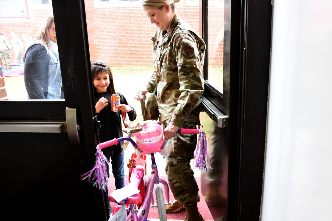 A young student of Badin Elementary School (B.E.S.) receives a bike during Operation Santa held at B.E.S., Badin, N.C., Dec. 14th, 2019.  Operation Santa is an annual event run by the Chapter 7 organization of the North Carolina Air National Guard (NCANG) which chooses select schools to provide assistance to families during the holiday season. This year, the NCANG provided presents, lunch, music, bouncy castles and a Santa. The NCANG also partnered with the local Target for food donations.