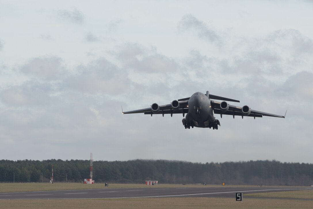 A C-17 Globemaster III assigned to the Heavy Airlift Wing, Pápa Air Base, Hungary, takes off after delivering the Boom Operator Weapon System Training System at RAF Mildenhall, England, Jan. 11, 2020. The BOWST is a simulator used by boom operators to provide hands-on training without leaving the ground. (U.S. Air Force photo by Senior Airman Benjamin Cooper)