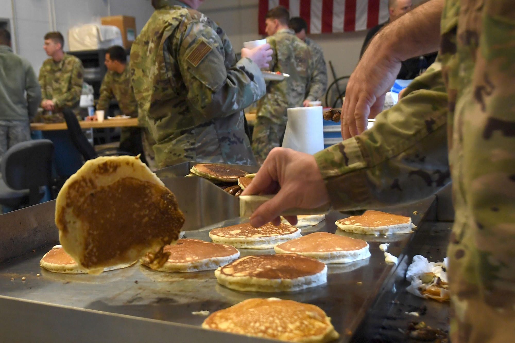 North Carolina Air National Guardsmen cook pancakes on a grill during a breakfast fundraiser, Jan. 12, 2020 at the 235th Air Traffic Control Squadron in New London, N.C. Members of the North Carolina Air National Guard as well as local airport authorities and law enforcement were invited to participate in a pancake breakfast social in order to strengthen community ties and build new relationships while raising funds for Morale, Welfare and Recreation.