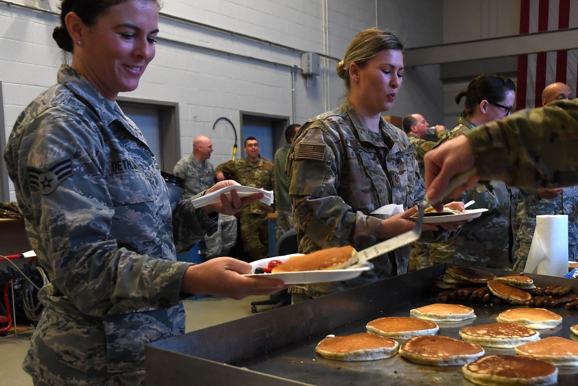 North Carolina Air National Guardsmen are served pancakes hot from the grill during a breakfast fundraiser, Jan. 12, 2020 at the 235th Air Traffic Control Squadron in New London, N.C. Members of the North Carolina Air National Guard as well as local airport authorities and law enforcement were invited to participate in a pancake breakfast social in order to strengthen community ties and build new relationships while raising funds for Morale, Welfare and Recreation.