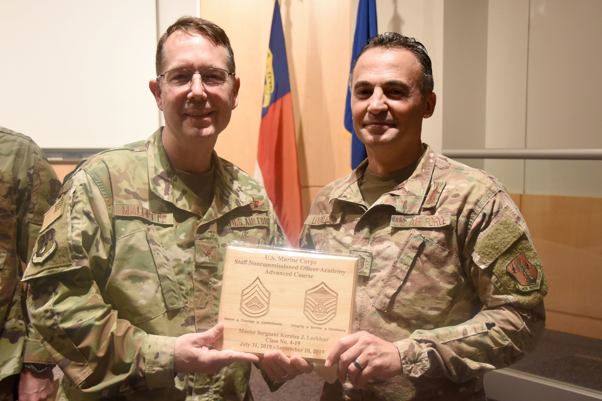 U.S. Air Force North Carolina Assistant Adjutant General for Air, Brig. Gen. Stephen Mallette (left), presents Master Sgt. Kernice Locklear, 263rd Combat Communications Squadron (right), with an award during an all-call held at the New London, N.C. Air National Guard Base (NCANG) headquarters, Jan. 12, 2020. Members of the NCANG celebrated the accomplishments of Master Sgt. Judd Locklear who attended the United States Marine Corps Staff Non-Commissioned Officer Academy last year in an effort to better understand the traditions and customs of a sister service. Since attending the academies, Locklear has implemented U.S. Marine Corps. practices such as sharing unit history and helping newer Airmen feel more involved with more responsibilities.