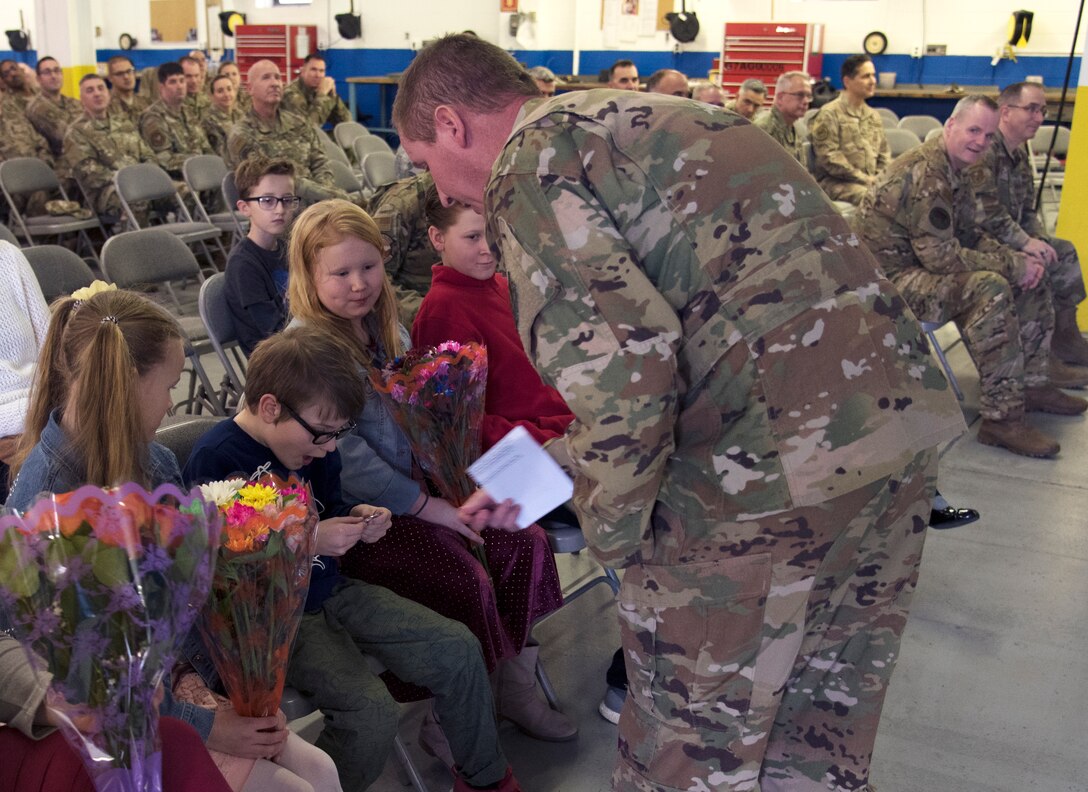 Lt. Col. Matthew Schnell coins his son after assuming command of the 108th Maintenance Squadron on Jan. 11, 2020, at Joint Base McGuire-Dix-Lakehurst, N.J. Schnell gave gifts to all family members in attendance during his initial address to the MXS.