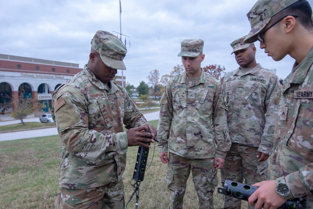 A group of DINFOS Basic Television Equipment Maintenance Course students practice assembling a NVIS antenna tower.