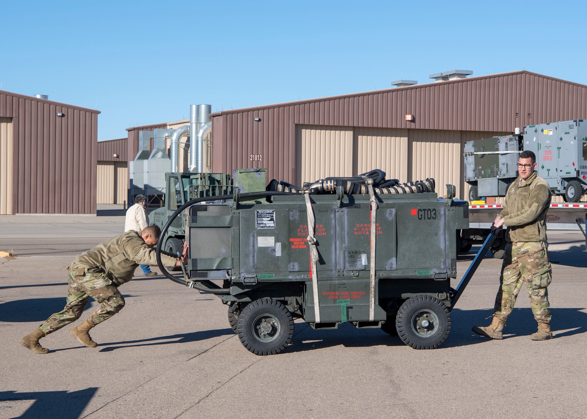 Airman 1st Class Mequail Fridge, 311th Aircraft Maintenance Unit support technician, pushes a ground power unit while Staff Sgt. Andrew Marsh, 311th AMU lead support technician, pulls it aside to be loaded onto a semi-truck, Jan. 6, 2020, on Holloman Air Force Base, N.M. Airmen from the 311th AMU packed and shipped all the additional tools and equipment they needed to complete their mission in Key West, Fla. (U.S. Air Force photo by Airman 1st Class Autumn Vogt)