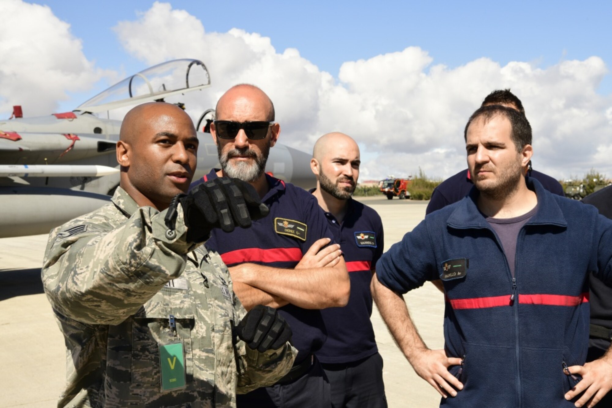 U.S. Air Force Staff Sgt. Bruce Lovett, 48th Civil Engineer Squadron fire fighter translates an emergency aircrew egress briefing to Spanish air force fire fighters during the Spanish-led air-to-air combat training exercise, OCEAN SKY 19 at Gando Air Base Oct. 20, 2019. Exercises like OCEAN SKY remain a symbol of the shared commitment between Spain, the U.S. and NATO to maintaining the continued security of Europe. (U.S. Air Force photo/ Tech. Sgt. Matthew Plew)