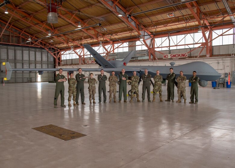 Some of the team who were directly involved the MQ-9 Reaper ferrying mission posed with the aircraft, Jan. 9, 2020, on Holloman Air Force Base, N.M. Airmen from the communications squadron, aircraft maintenance unit, and the 29th Attack Squadron were some of the members who ensured the success of ferrying an MQ-9 from California to Holloman. (U.S. Air Force photo by Airman 1st Class Autumn Vogt)