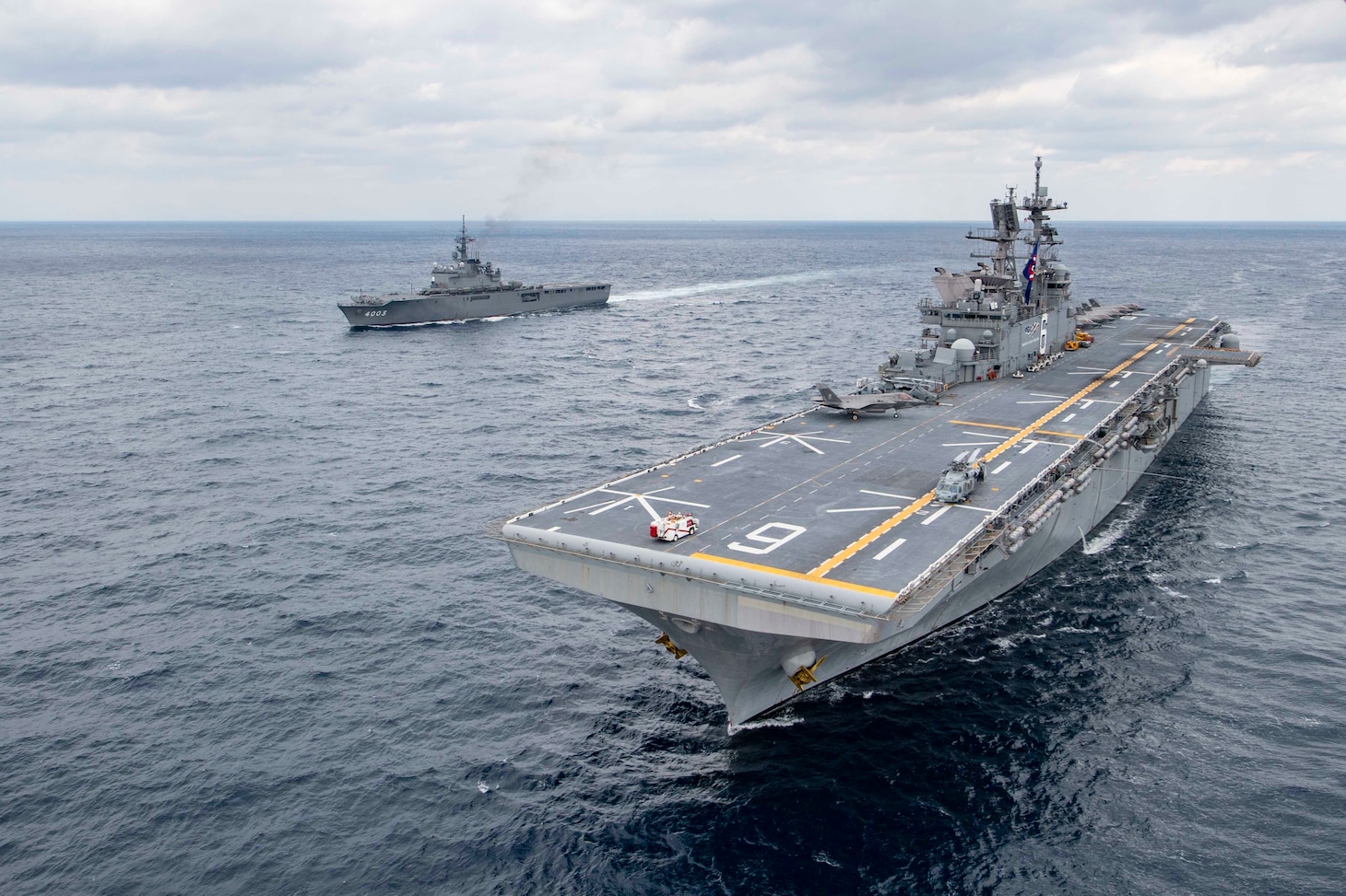 Amphibious assault ship USS America (LHA 6) and Japan Maritime Self-Defense Force amphibious transport dock ship JS Kunisaki (LST 4003) operate together in the East China Sea.