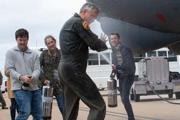 Friends and family spray Col. Burgess with water as he laughs.