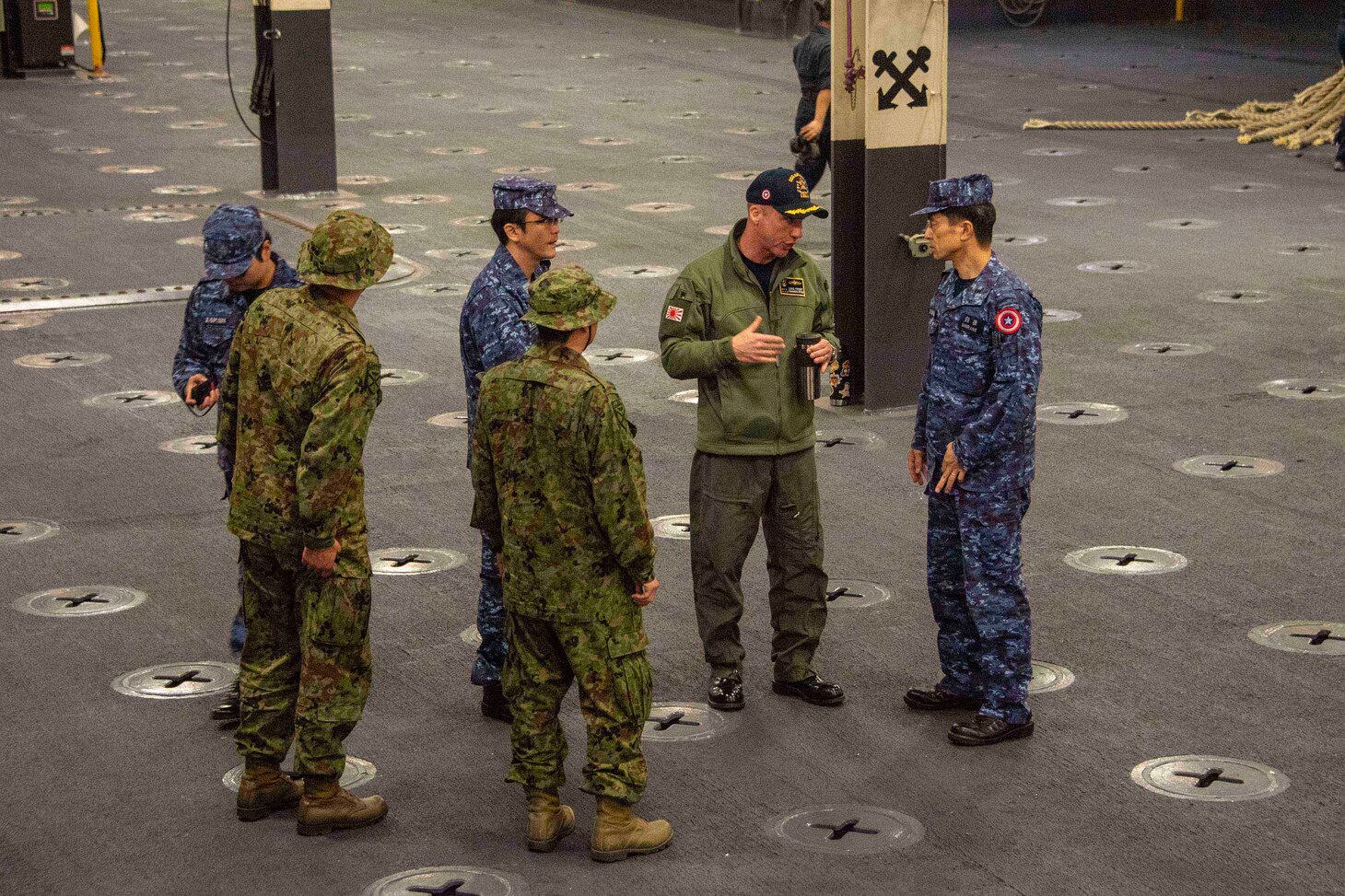 EAST CHINA SEA (Jan. 13, 2020) Capt. Luke Frost, commanding officer aboard amphibious assault ship USS America (LHA 6) gives a tour of the ship’s vehicle stowage area to Japan Maritime Self-Defense Force (JMSDF) Rear Adm. Shirane Tsutomu, commander, JMSDF Mine Warfare Force. The America Expeditionary Strike Group, 31st Marine Expeditionary Unit team is operating in the U.S. 7th Fleet area of operations to enhance interoperability with allies and partners and serve as a ready response force to defend peace and stability in the Indo-Pacific region.