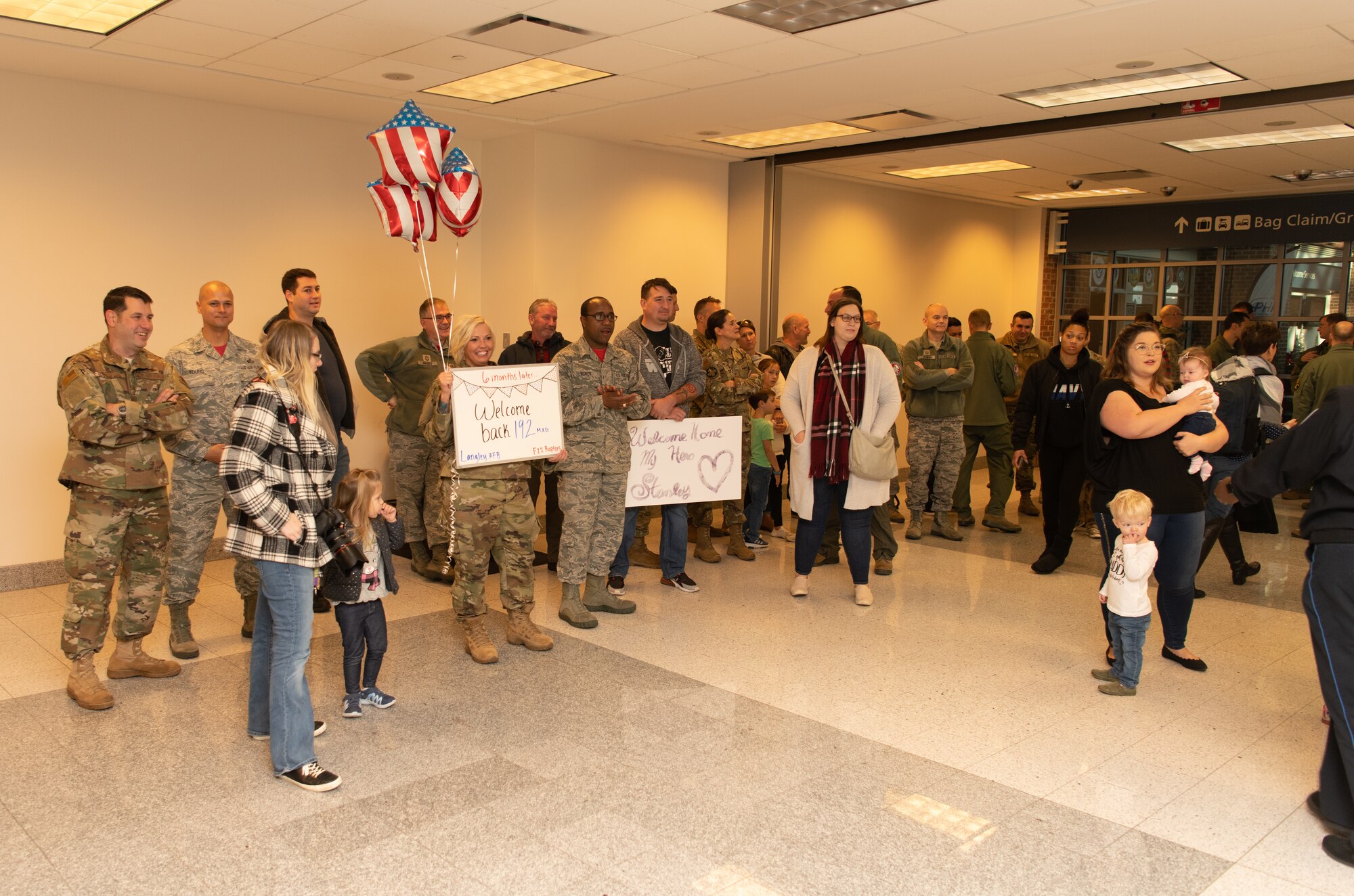 Airmen at an airport return from a deployment