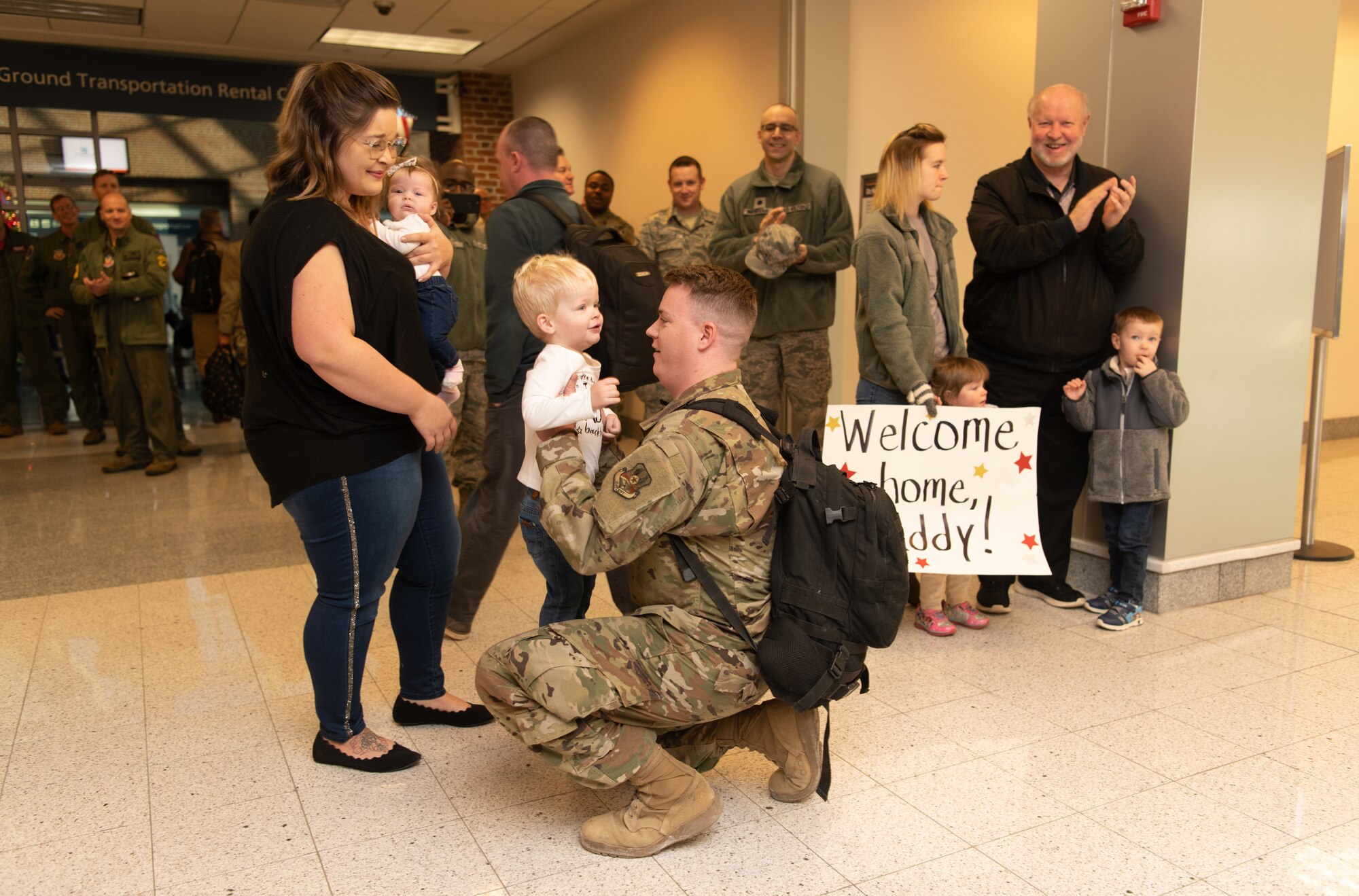 Airmen at an airport return from a deployment
